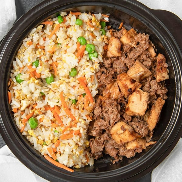 Fresh Millions Restaurant's fried rice with peas and carrots, alongside grilled chicken and ground beef.